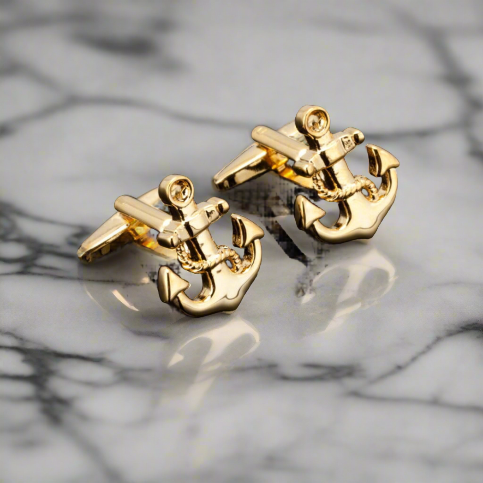 Gold anchor cufflinks displayed on a light gray suit, highlighting sophisticated style.