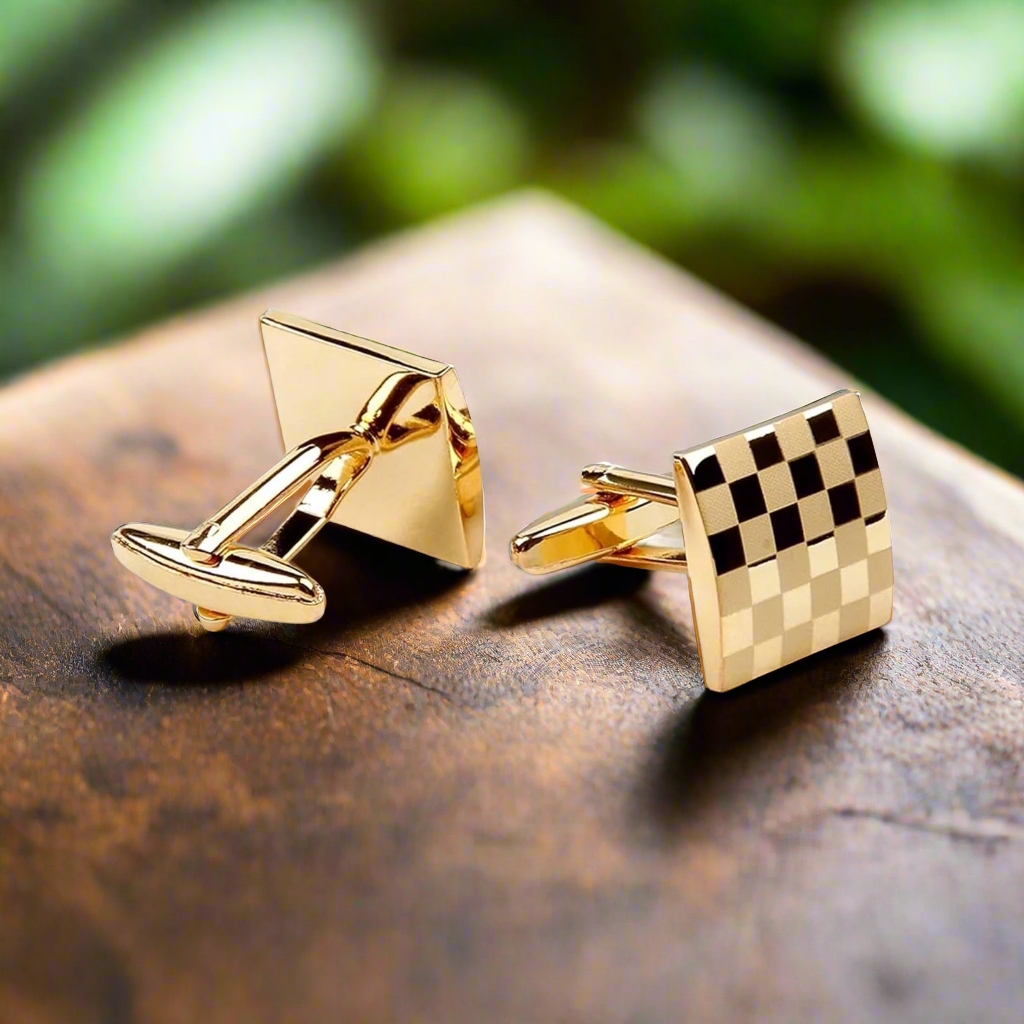 Gold cufflinks with a check pattern displayed on a white dress shirt