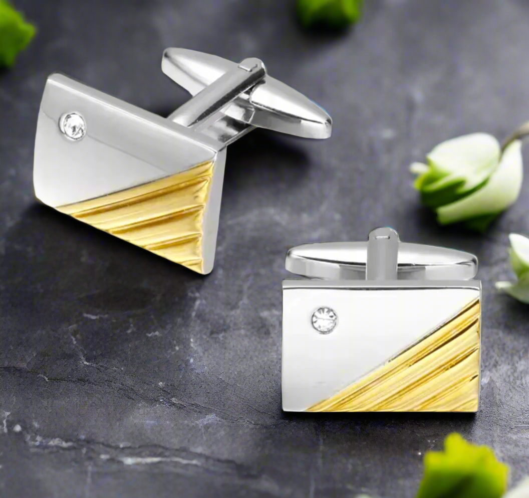 Luxury chrome cufflinks with red stone, angled view