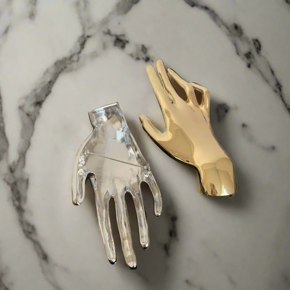 Gold hand lapel pin on a men's suit lapel, close-up shot