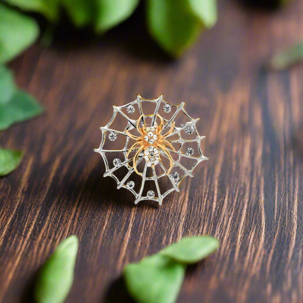 Front view of silver and gold spider web lapel pin on a suit jacket