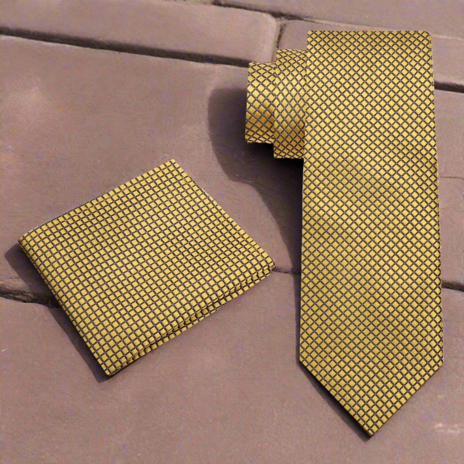 Silk tie with geometric pattern and metallic finish draped over a suit