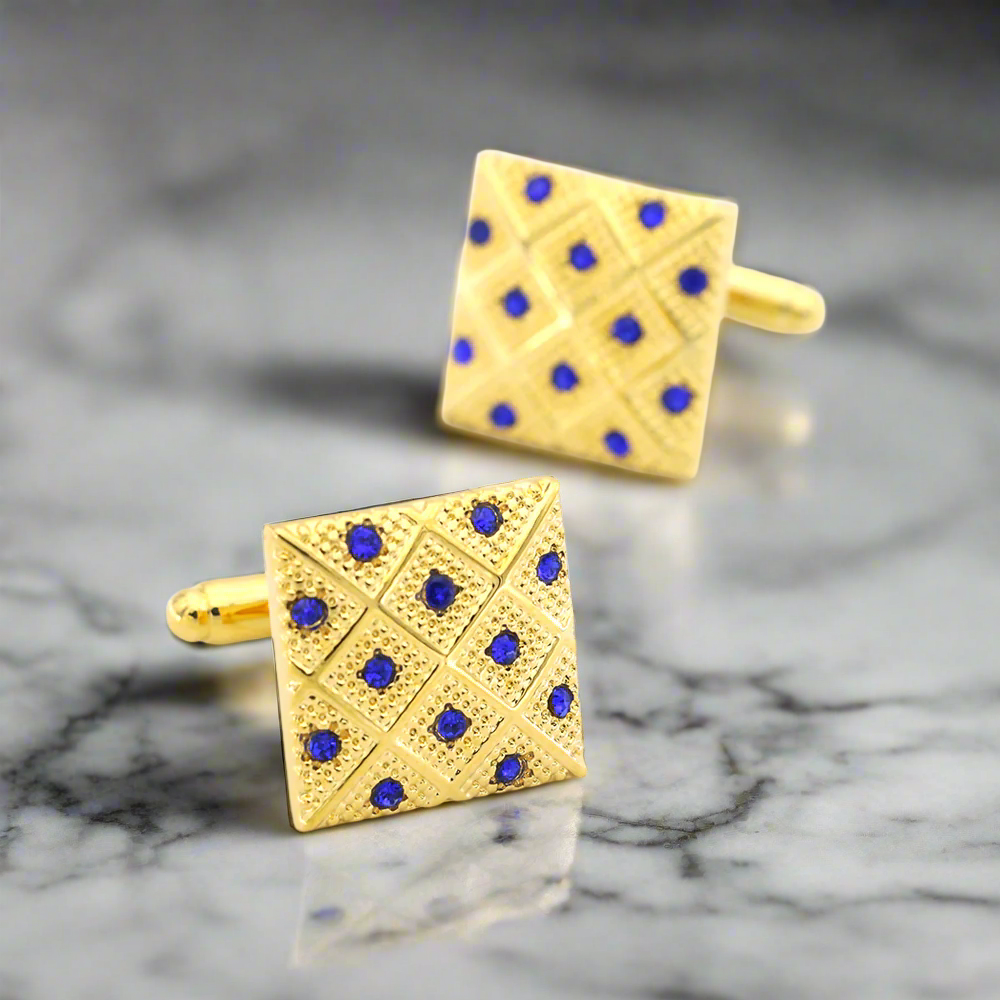 Side angle of square gold cufflinks with checkerboard design, styled with a navy suit.