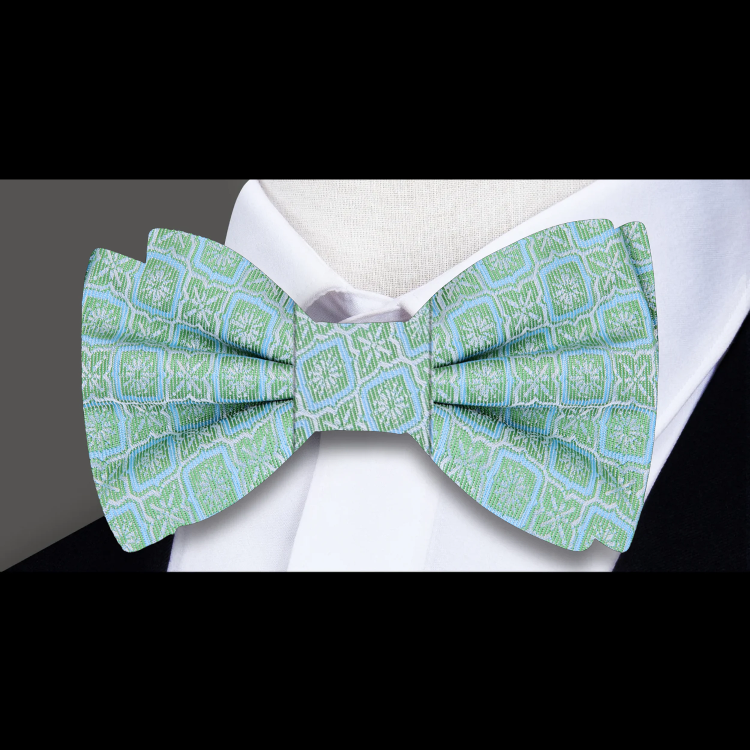 Model wearing the vibrant geometric silk bow tie with a light blue dress shirt at a wedding.
