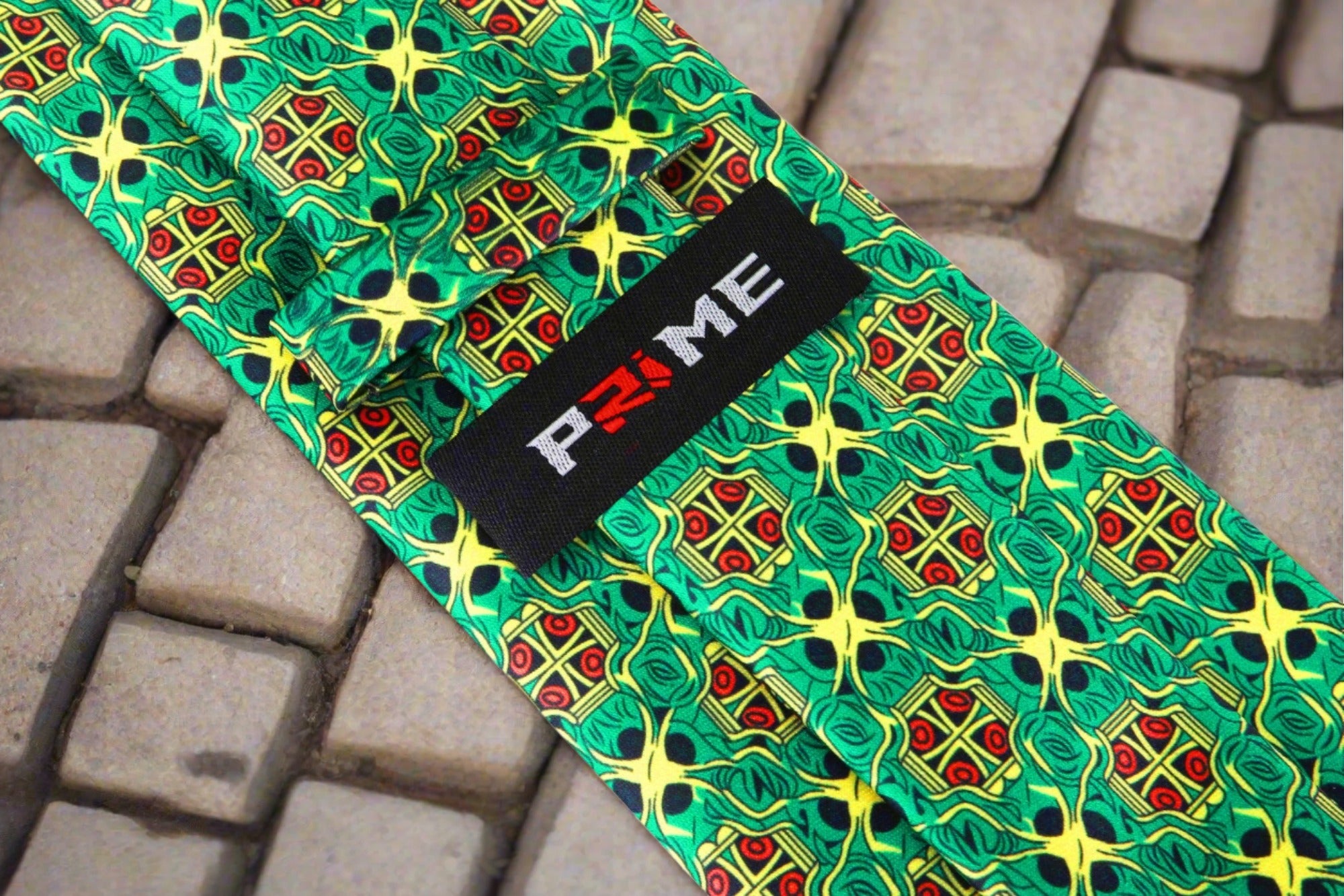 The green abstract necktie elegantly displayed against a white dress shirt, showcasing its bold colors.