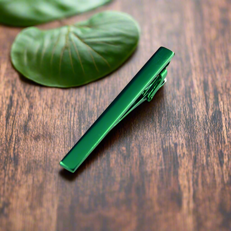 Close-up of polished chrome tie bar clipped onto navy silk tie