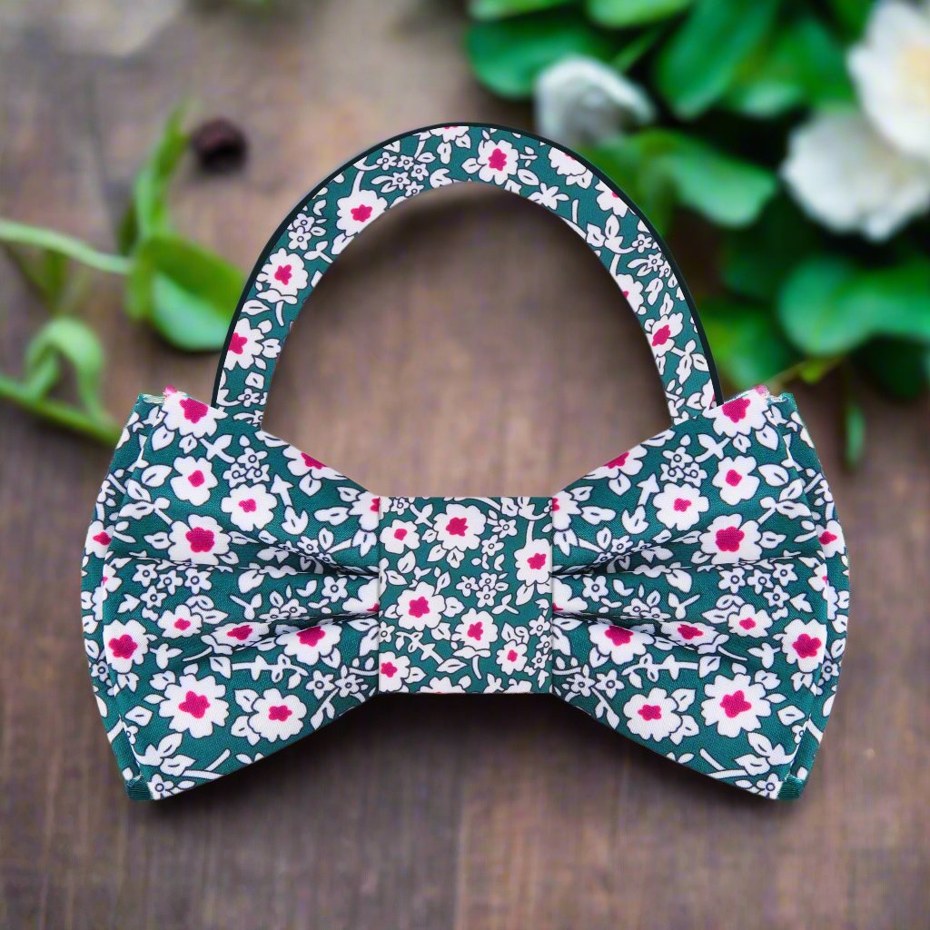 Close-up of floral bow tie in vibrant green, white, and reddish pink patterns, perfect for weddings