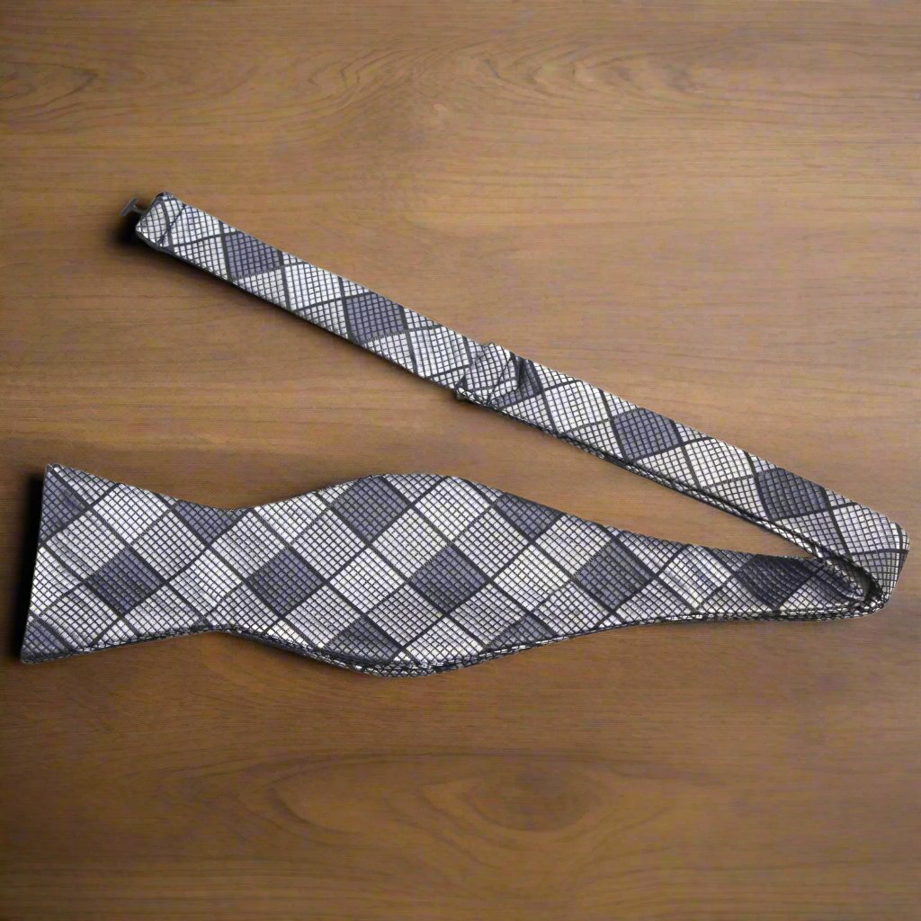 Model wearing a stylish geometric silk bow tie with a navy suit for a business meeting