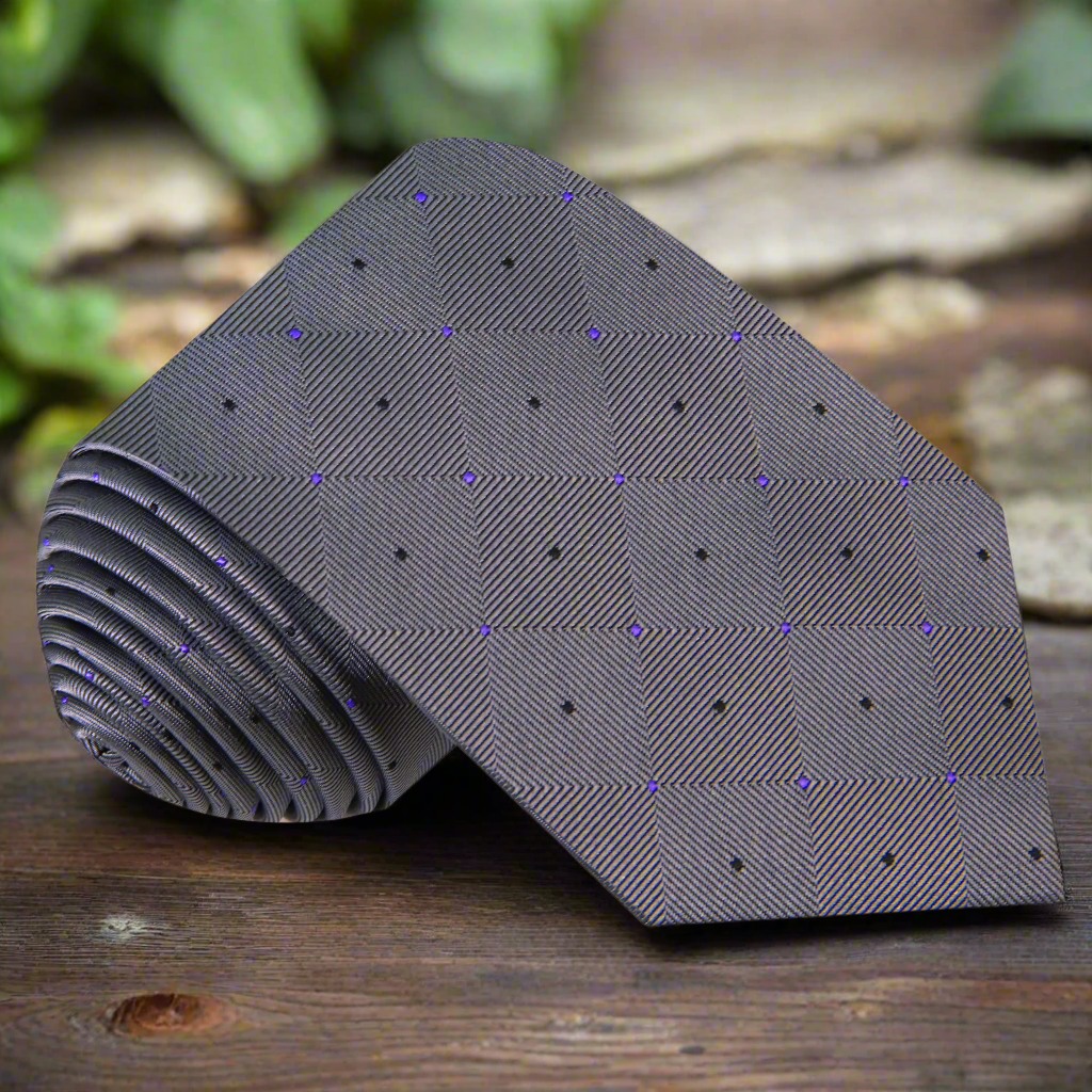Close-up of a geometric patterned men's necktie in grey, purple, and black, suitable for business meetings