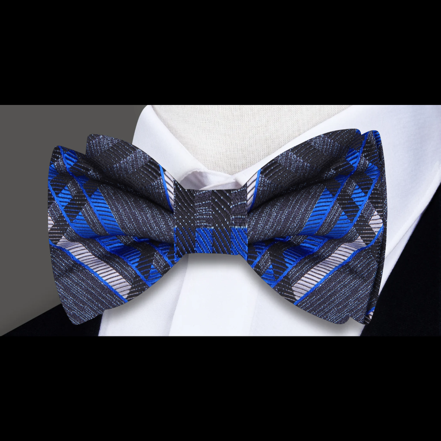 Dark blue plaid bow tie on a white dress shirt, perfect for formal events.