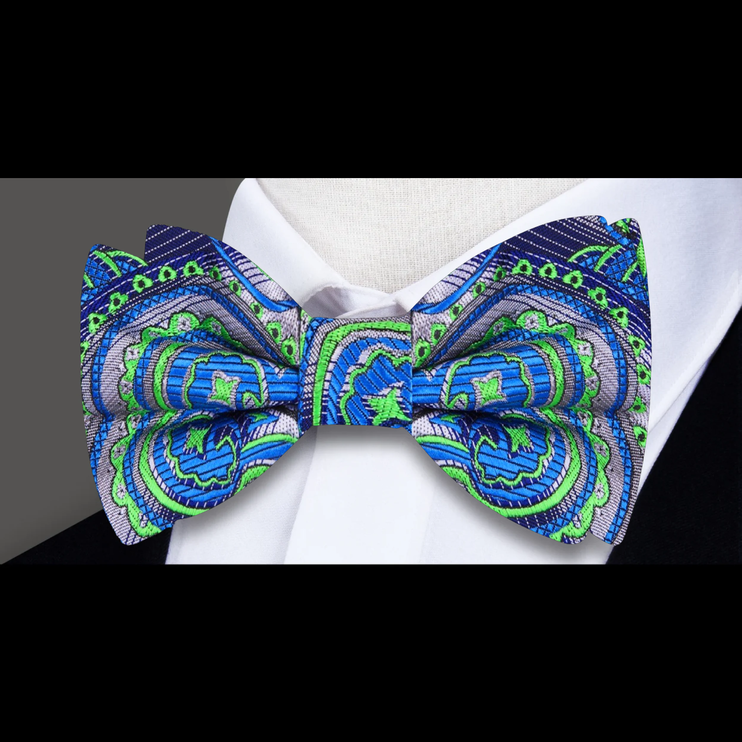 Tropics Paisley Bow Tie and matching pocket square, laid out against a dark suit background.