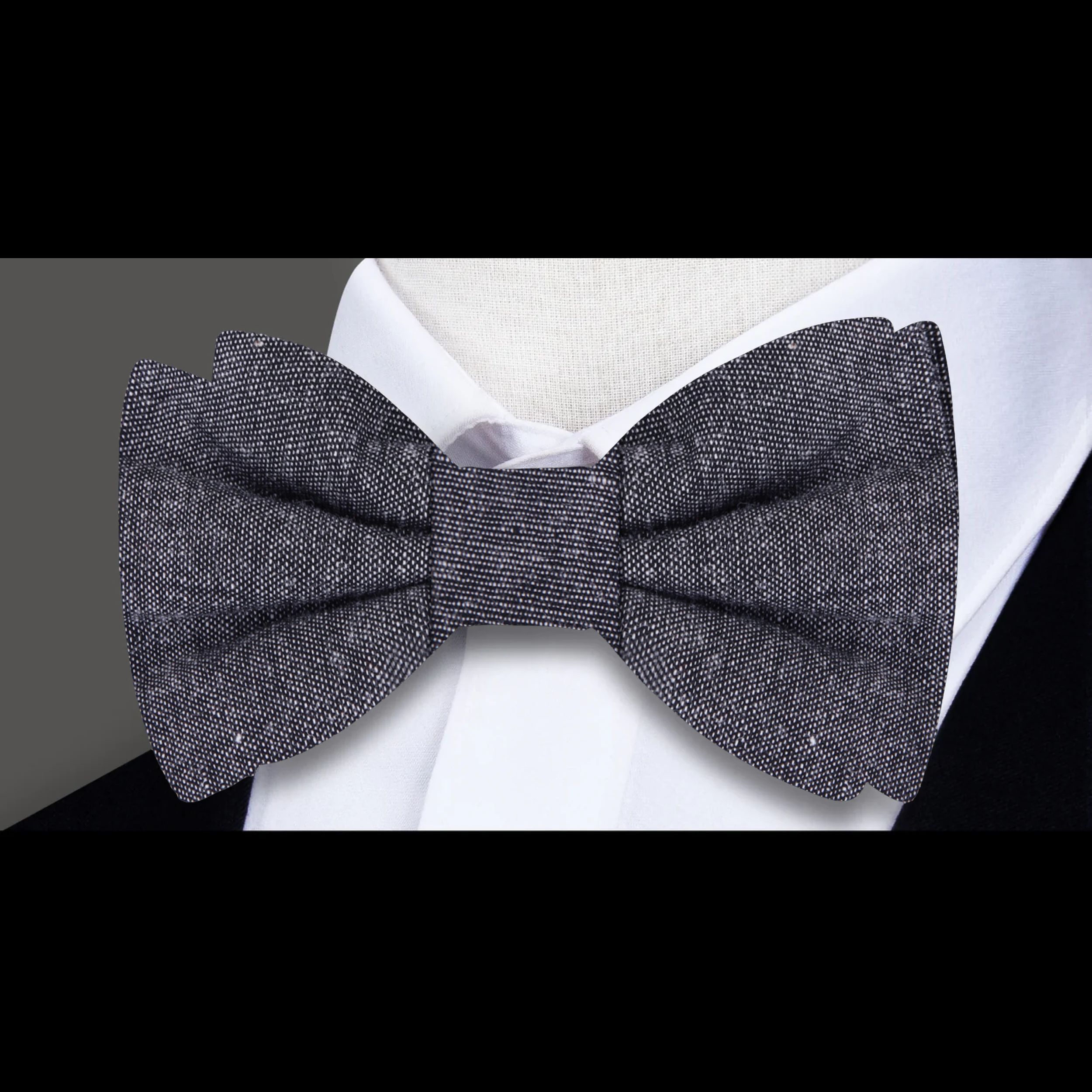 Groom wearing a navy linen bow tie with pocket square at a wedding reception