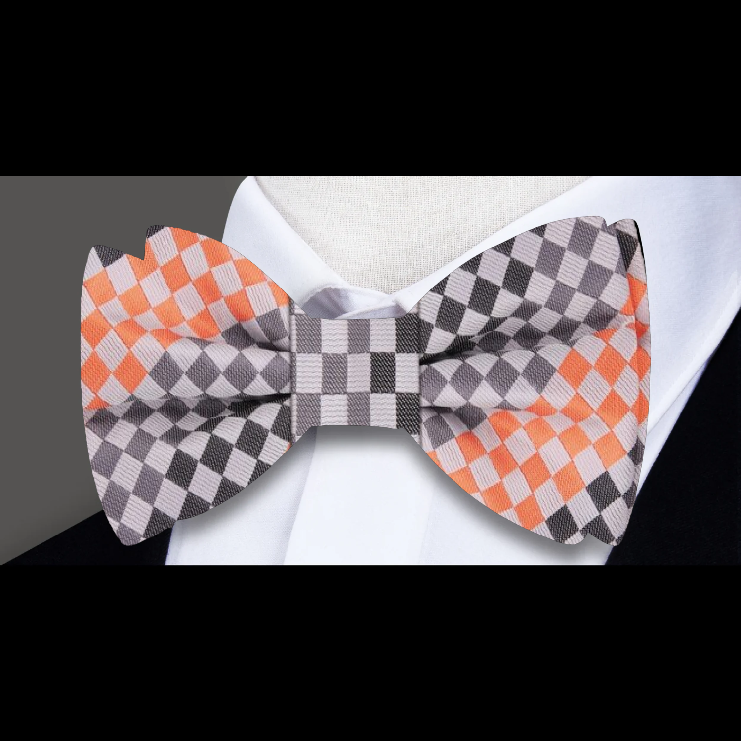 Man adjusting a stylish silk bow tie with geometric pattern at a wedding