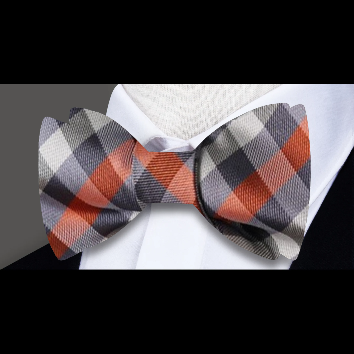 Styled shot of a geometric check bow tie paired with a classic suit for a sophisticated look