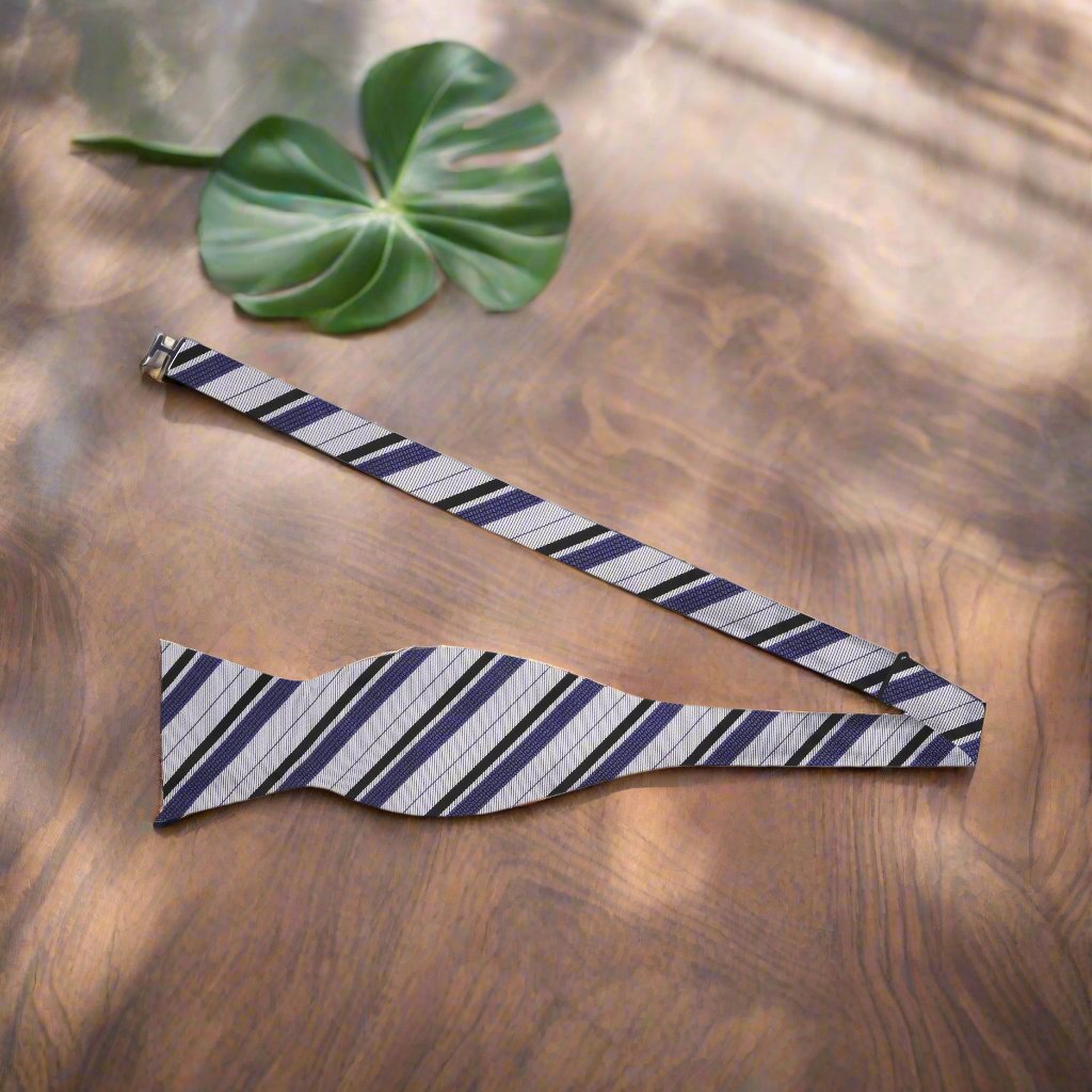 Close-up view of the grey, black, and purple stripe silk bow tie, showcasing its luxurious texture.