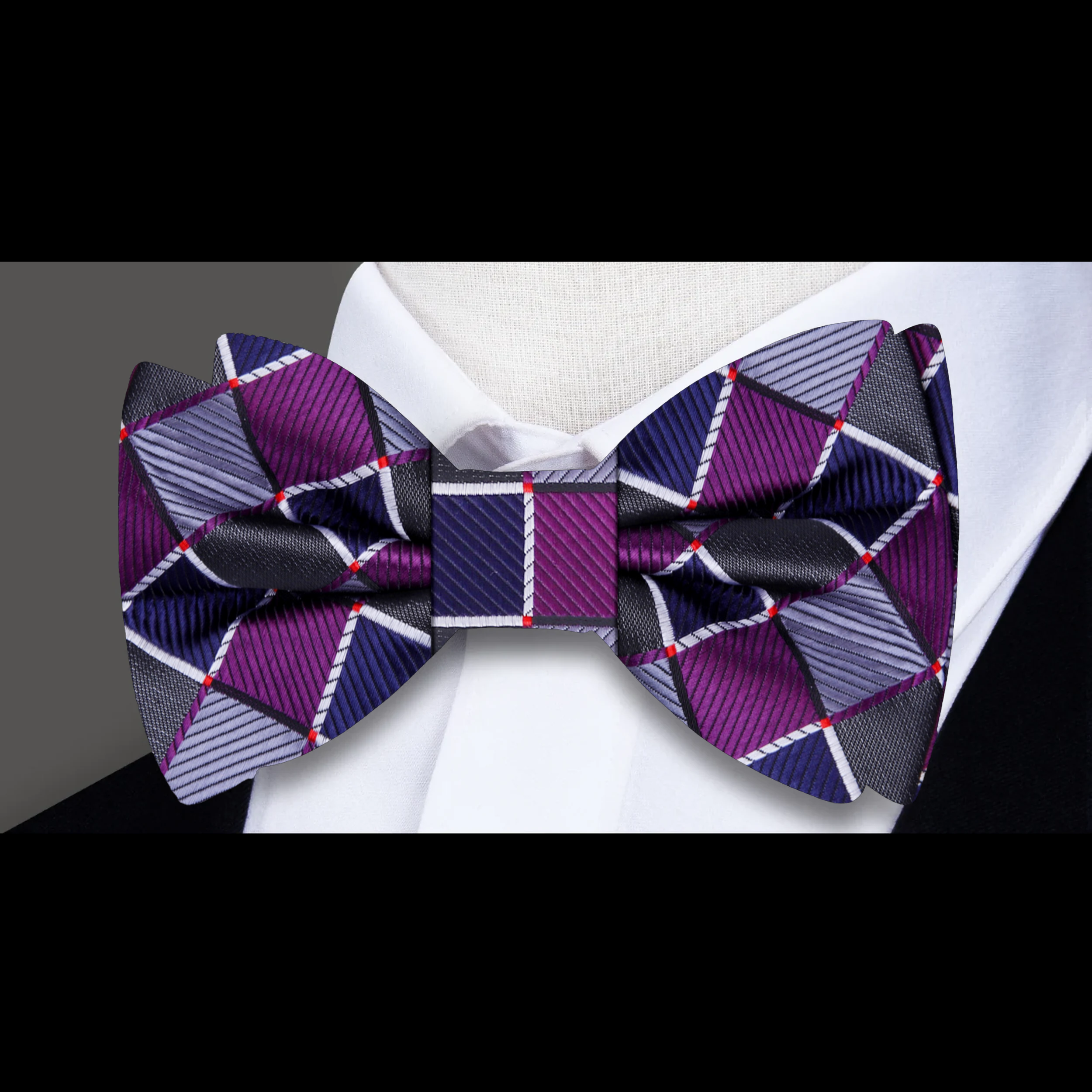 Man wearing a geometric silk bow tie with a matching pocket square, stylish and modern