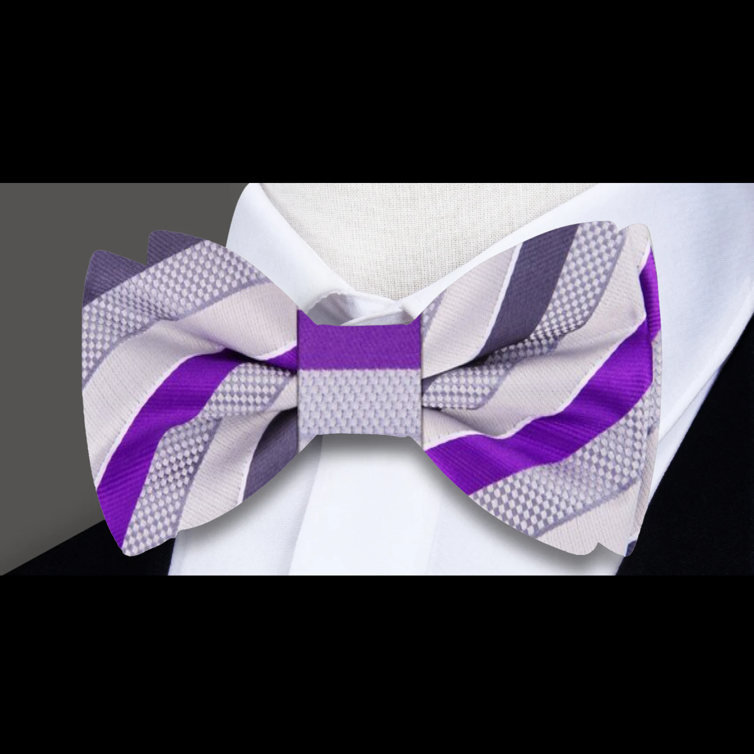 Elegant grey and purple stripe bow tie displayed on a suit