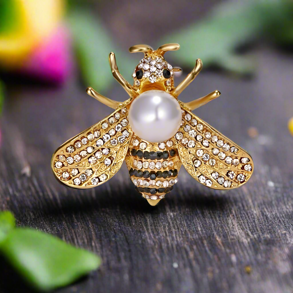 Different variations of the honey bee lapel pin including gold and pearl designs