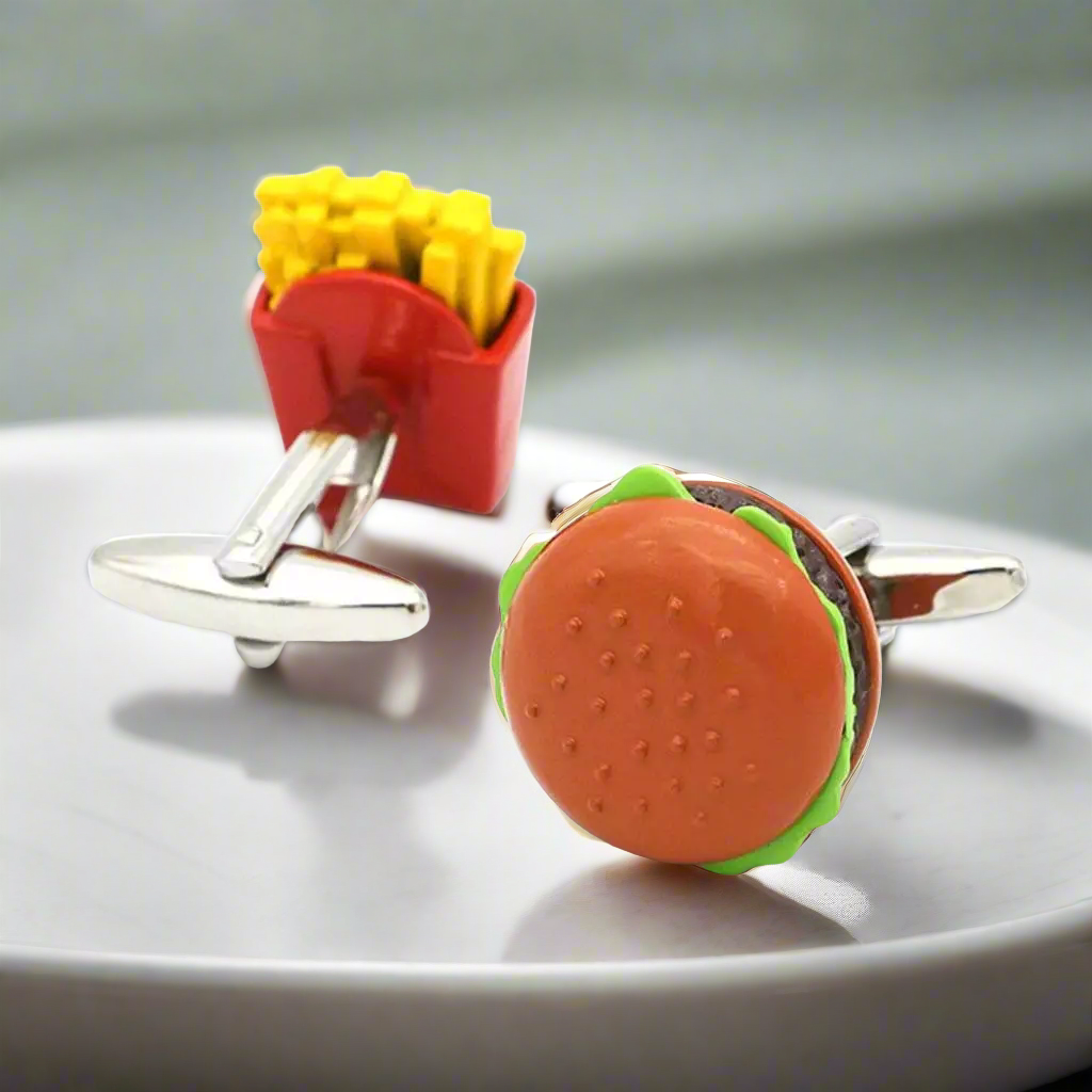 Close-up of hamburger and fries cufflinks against a white dress shirt.