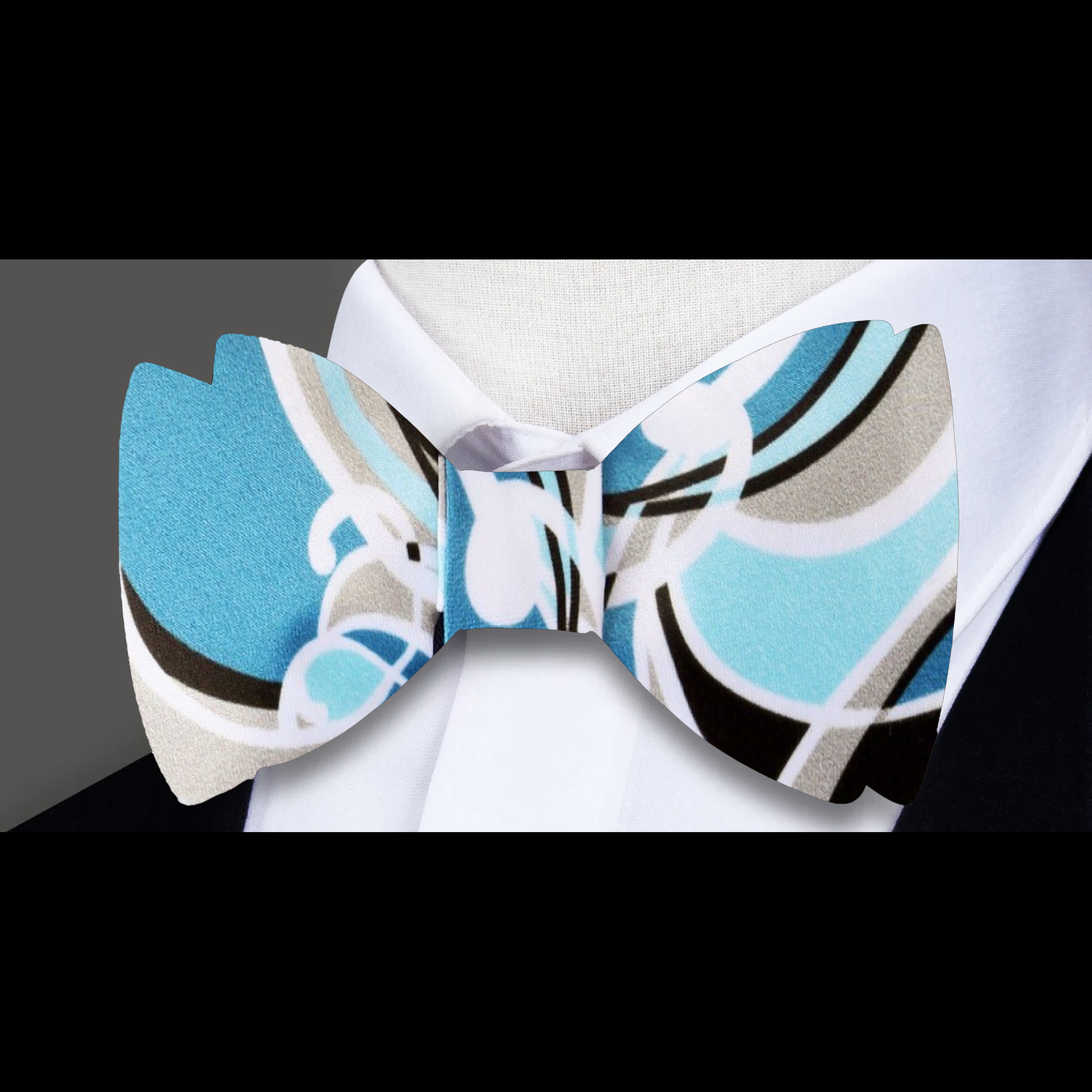 Model wearing a self-tie silk bow tie with matching pocket square at an art gallery event