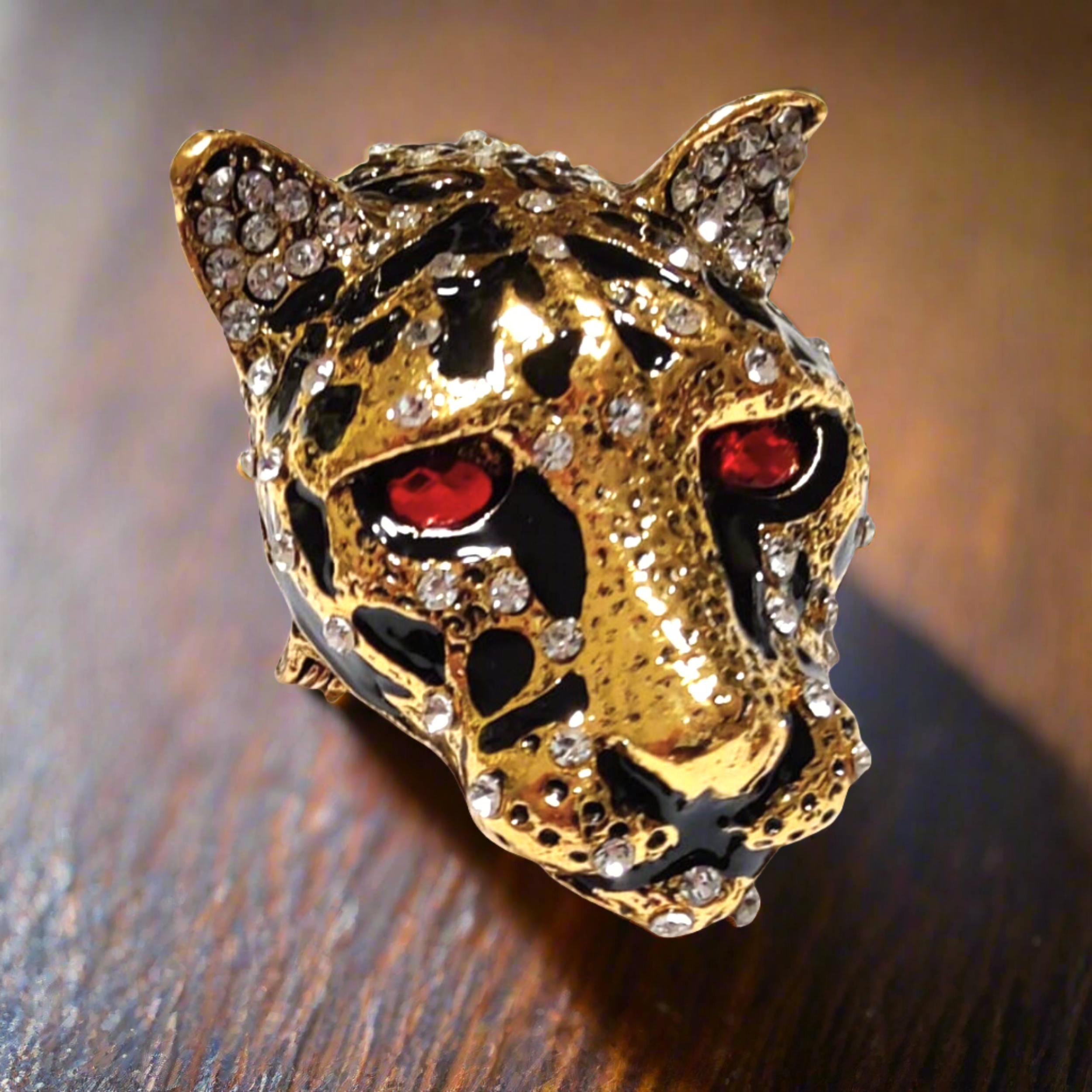 Close-up of the Leopard Head Lapel Pin featuring red and clear gemstones.