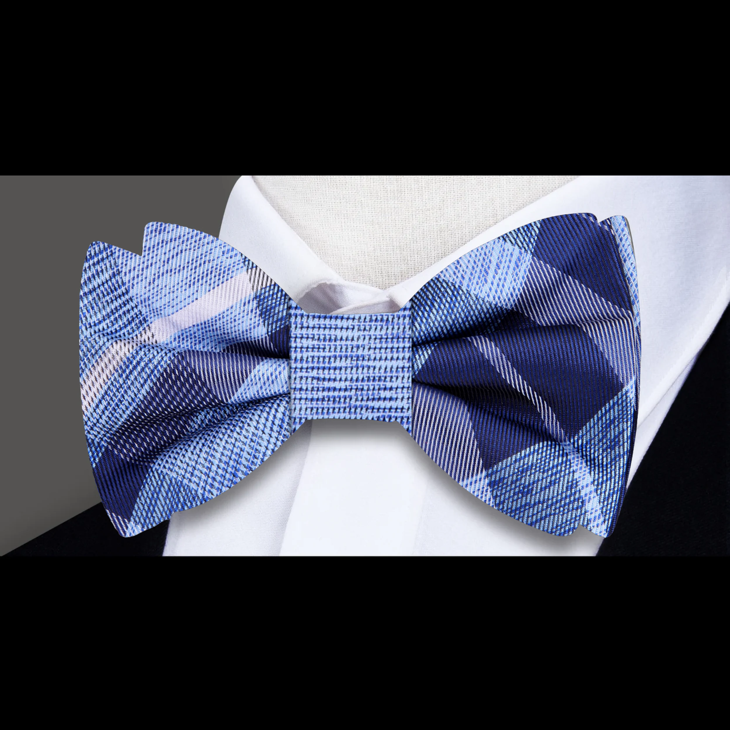 Model wearing plaid bow tie and matching pocket square with suit