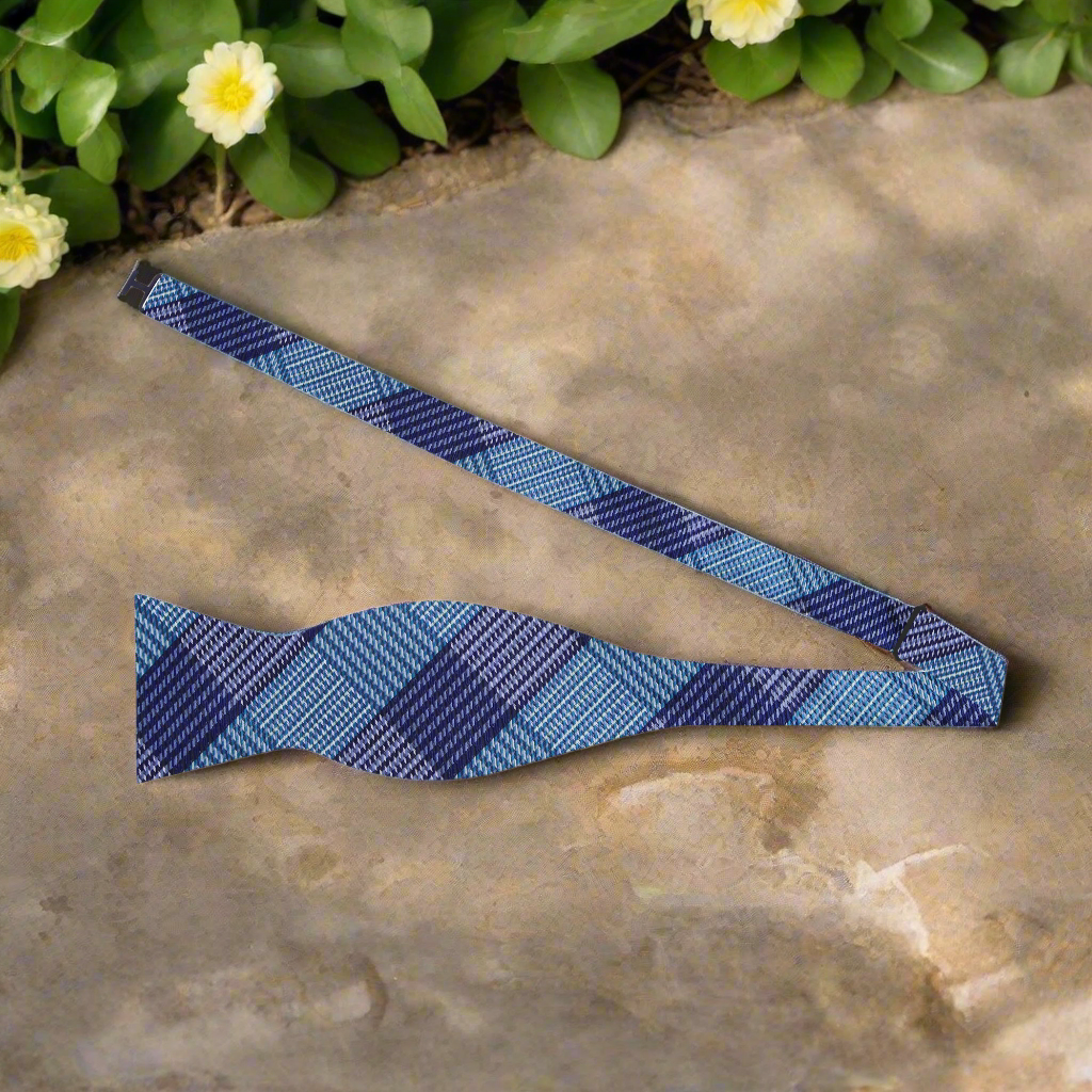 Close-up of silk plaid bow tie in blue and purple, styled with a white dress shirt