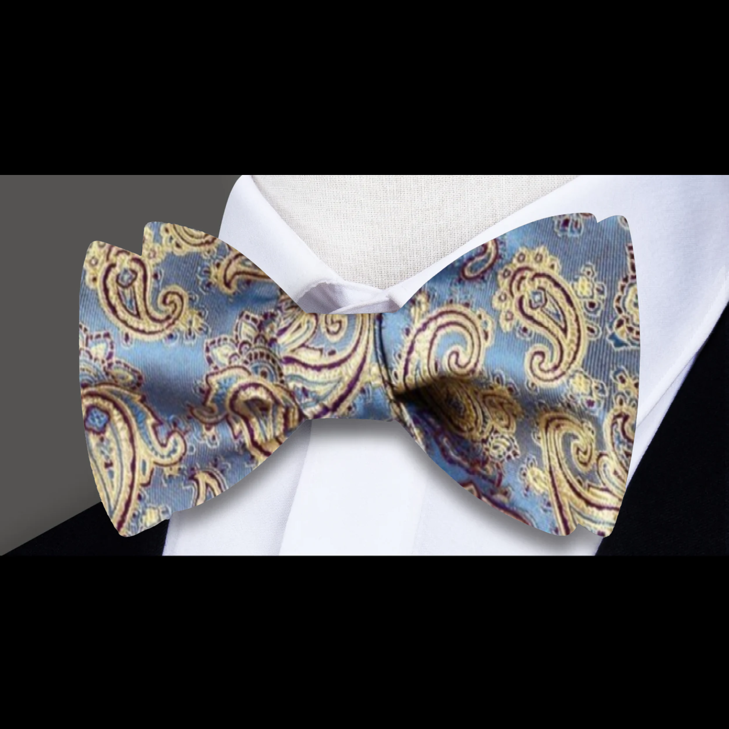 Close-up of a colorful pre tied bow tie with pocket square in vibrant paisley pattern.