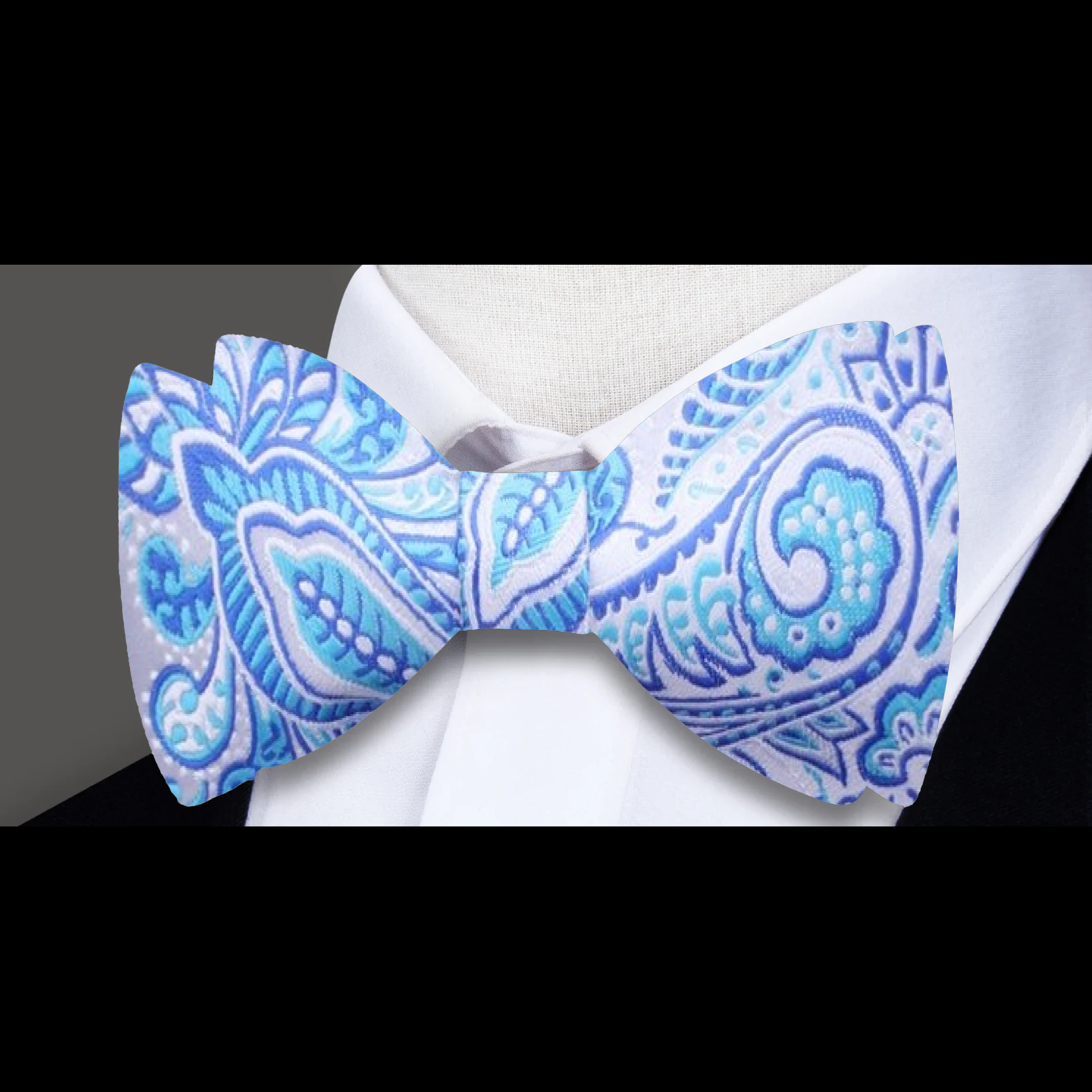 Close-up of the elegant paisley self-tie bow tie showcasing its intricate design in light blue and rust.