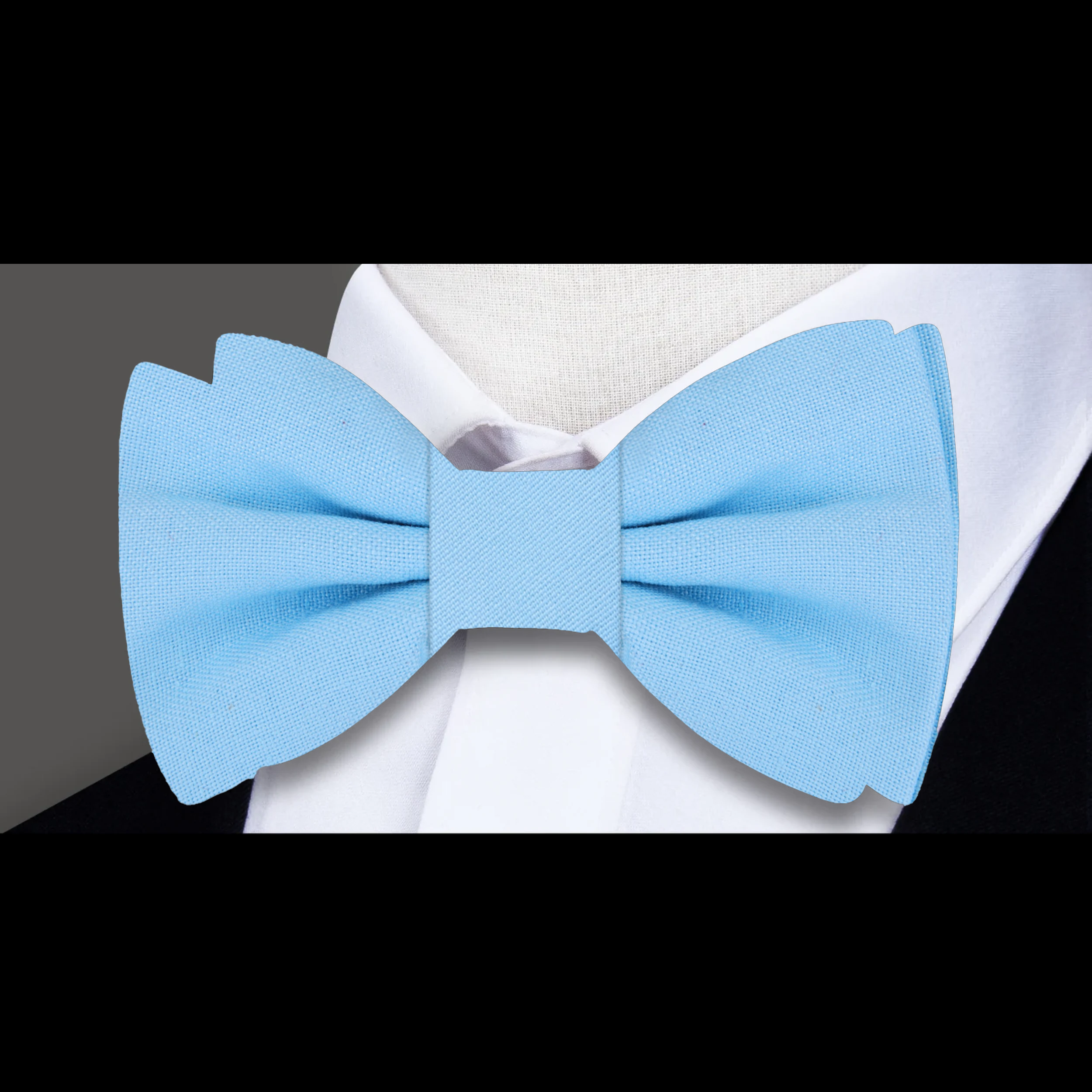 Groom wearing a navy linen bow tie with pocket square at a wedding reception