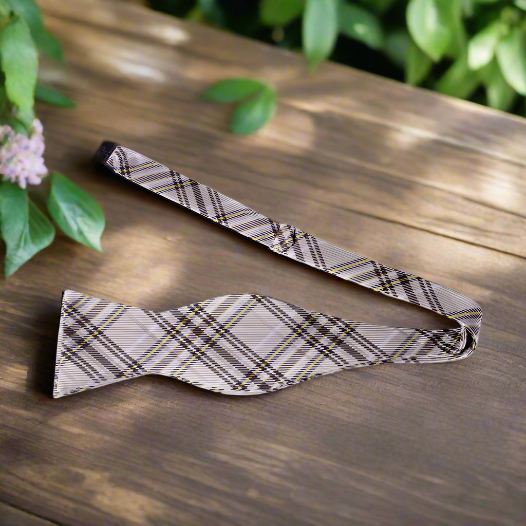 Flat lay of the self tie bow tie and matching pocket square on a light grey suit