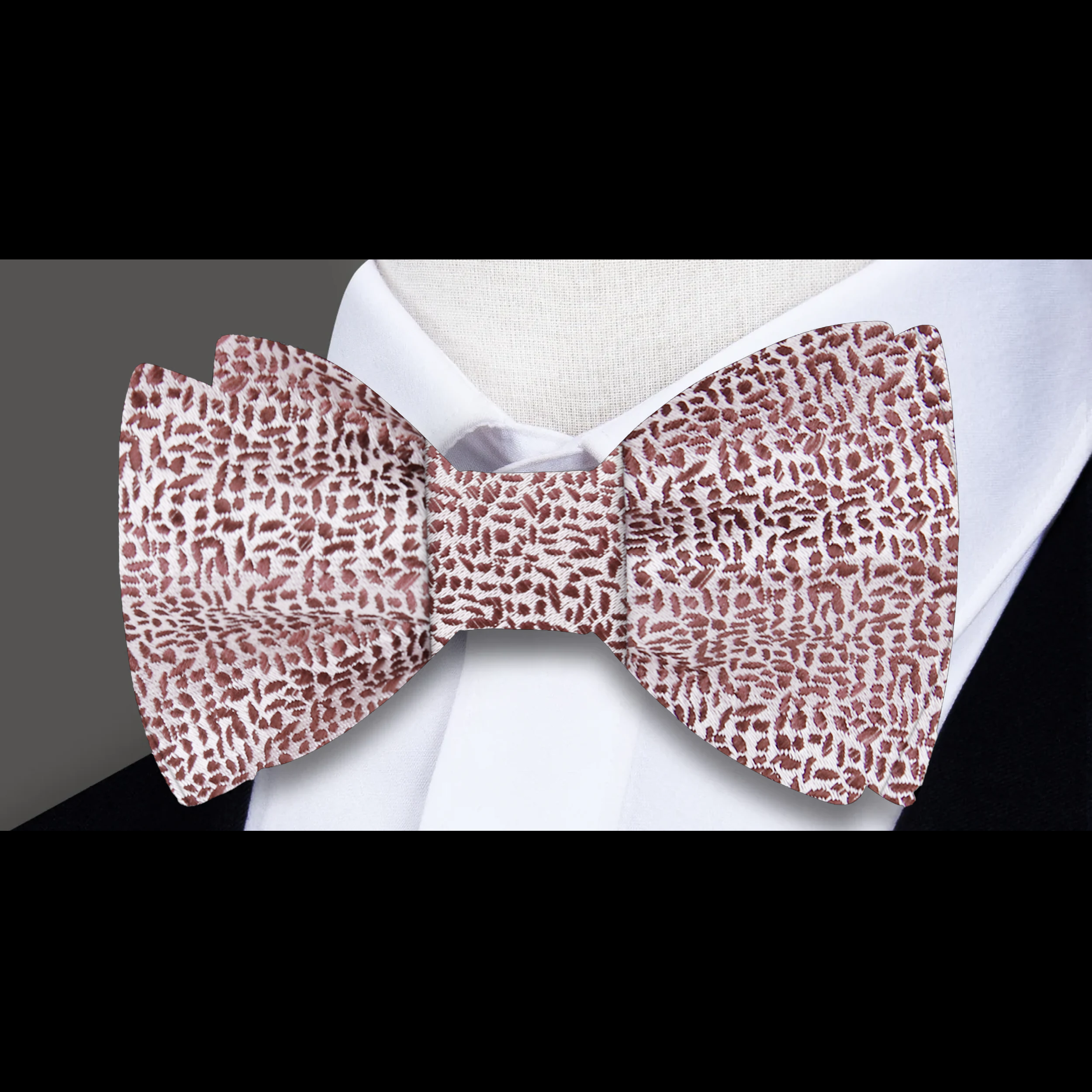 Close-up view of a grey textured silk bow tie with detailed fabric pattern
