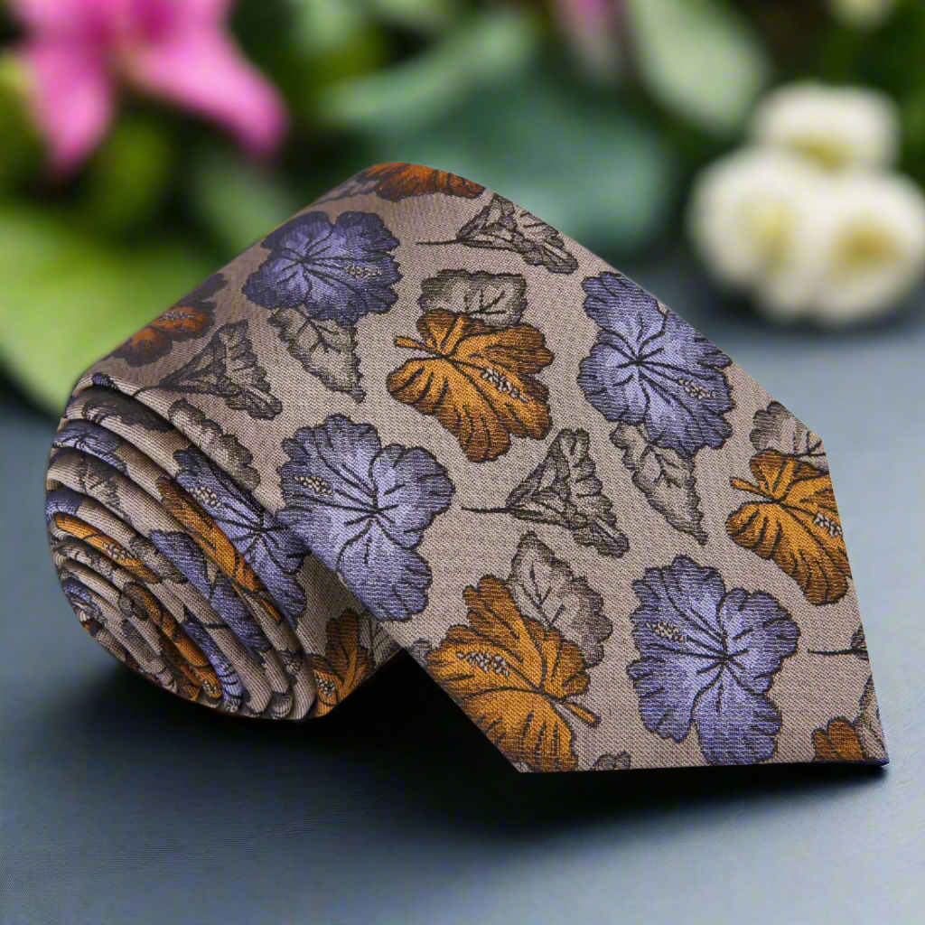 Close-up of a floral silk necktie in light brown with purple and amber accents, ideal for formal wear