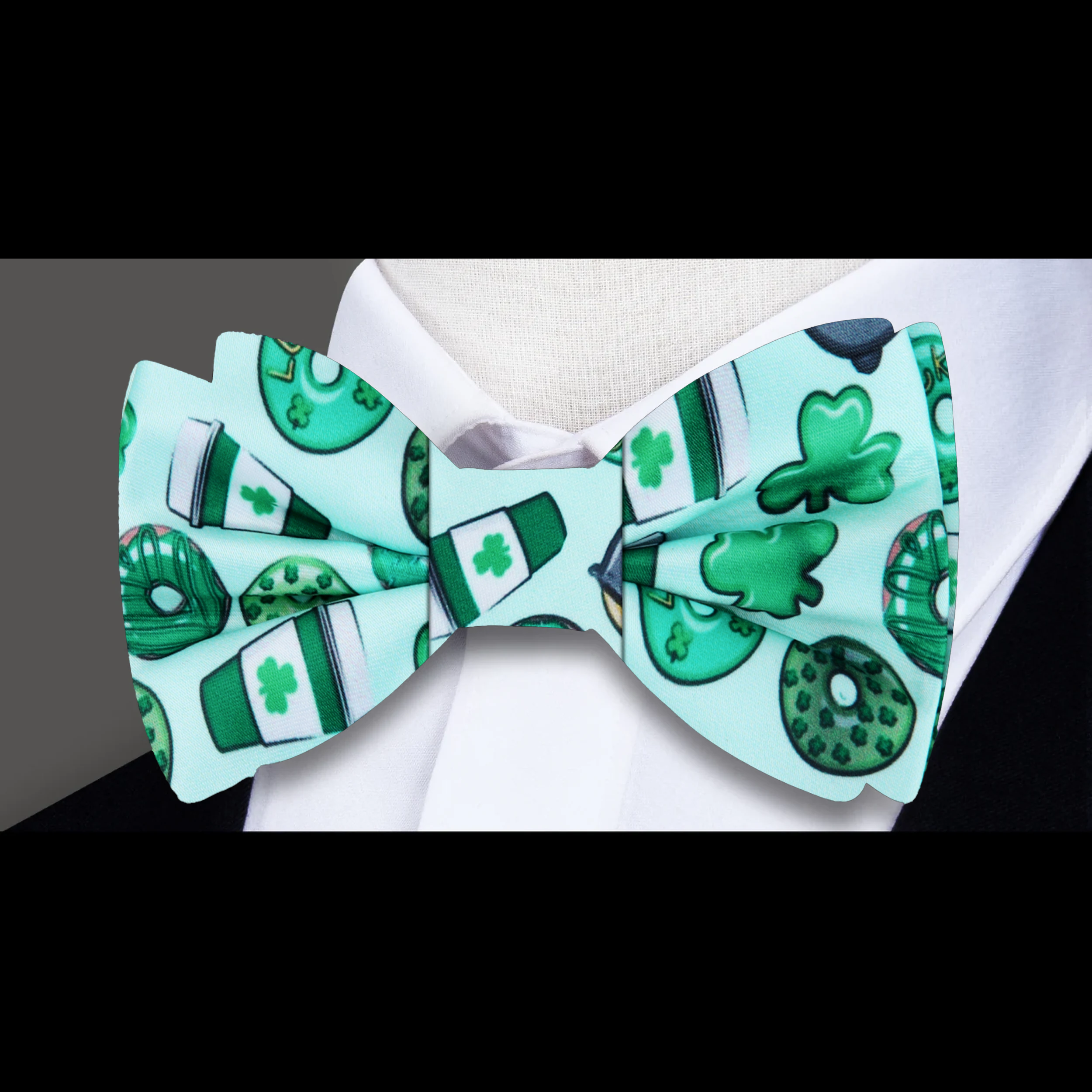 Close-up of whimsical green silk bow tie with coffee and donut motifs for St. Patricks Day