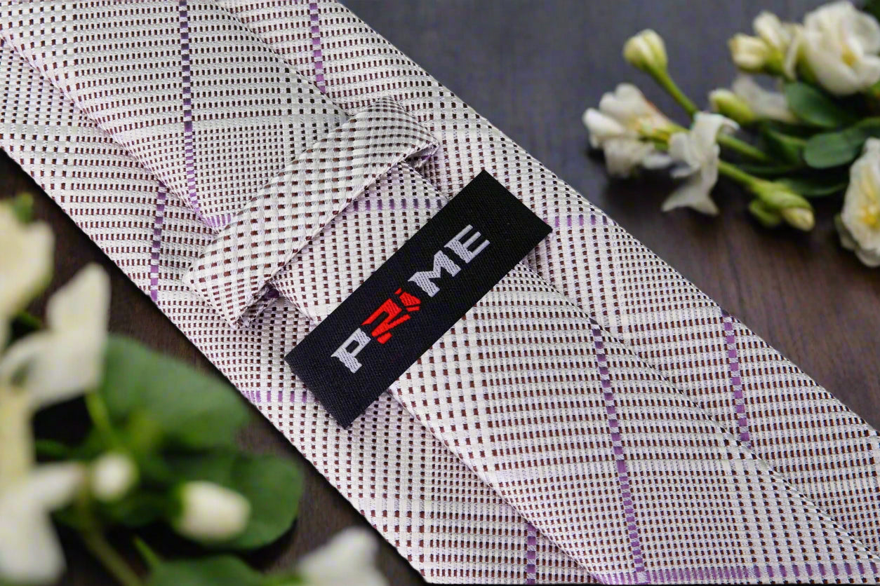 Close-up of grey and purple silk plaid necktie folded neatly with pocket square