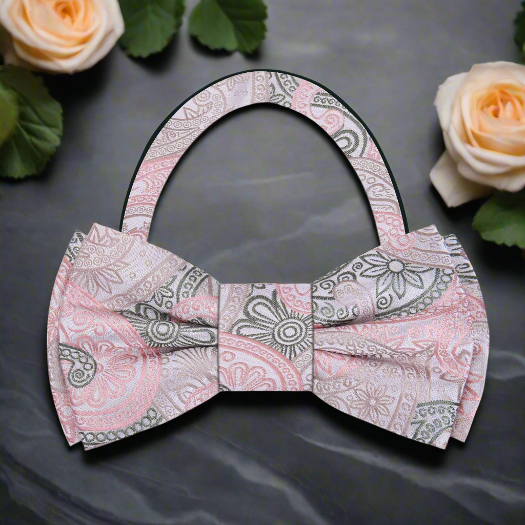 Close-up of a silk paisley bow tie showcasing vibrant pink, peach, and green colors