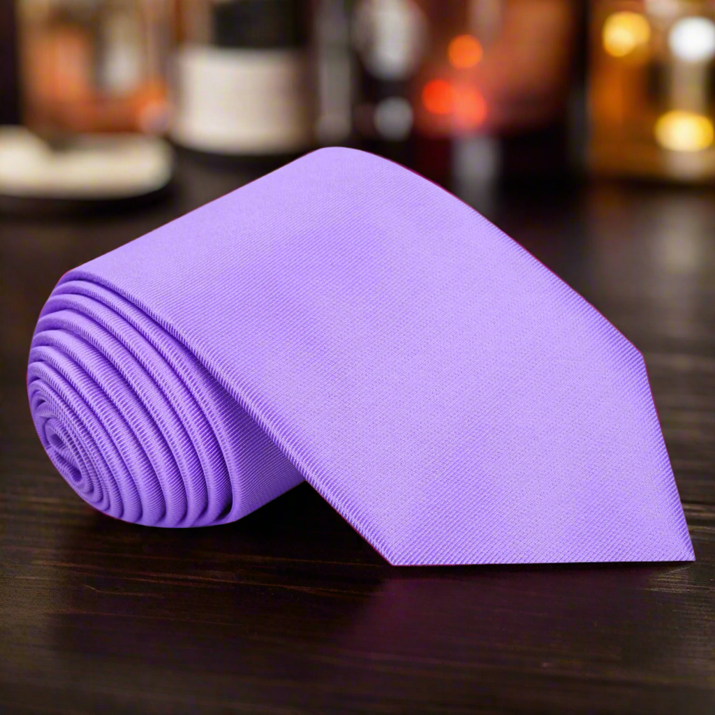 Elegant solid purple silk necktie displayed against a white background, showcasing its luxurious texture.