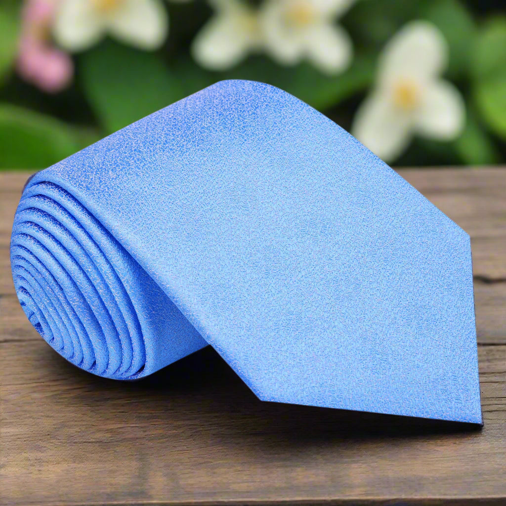 Light blue silk tie with shimmering texture displayed on a mannequin for wedding attire