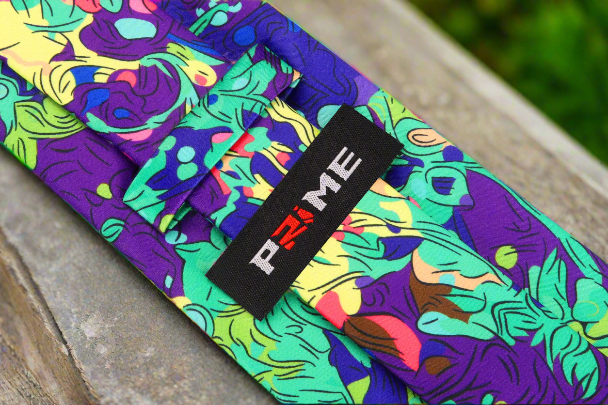 Artisan Mosaic Abstract Necktie with vibrant colors displayed on a wooden table.