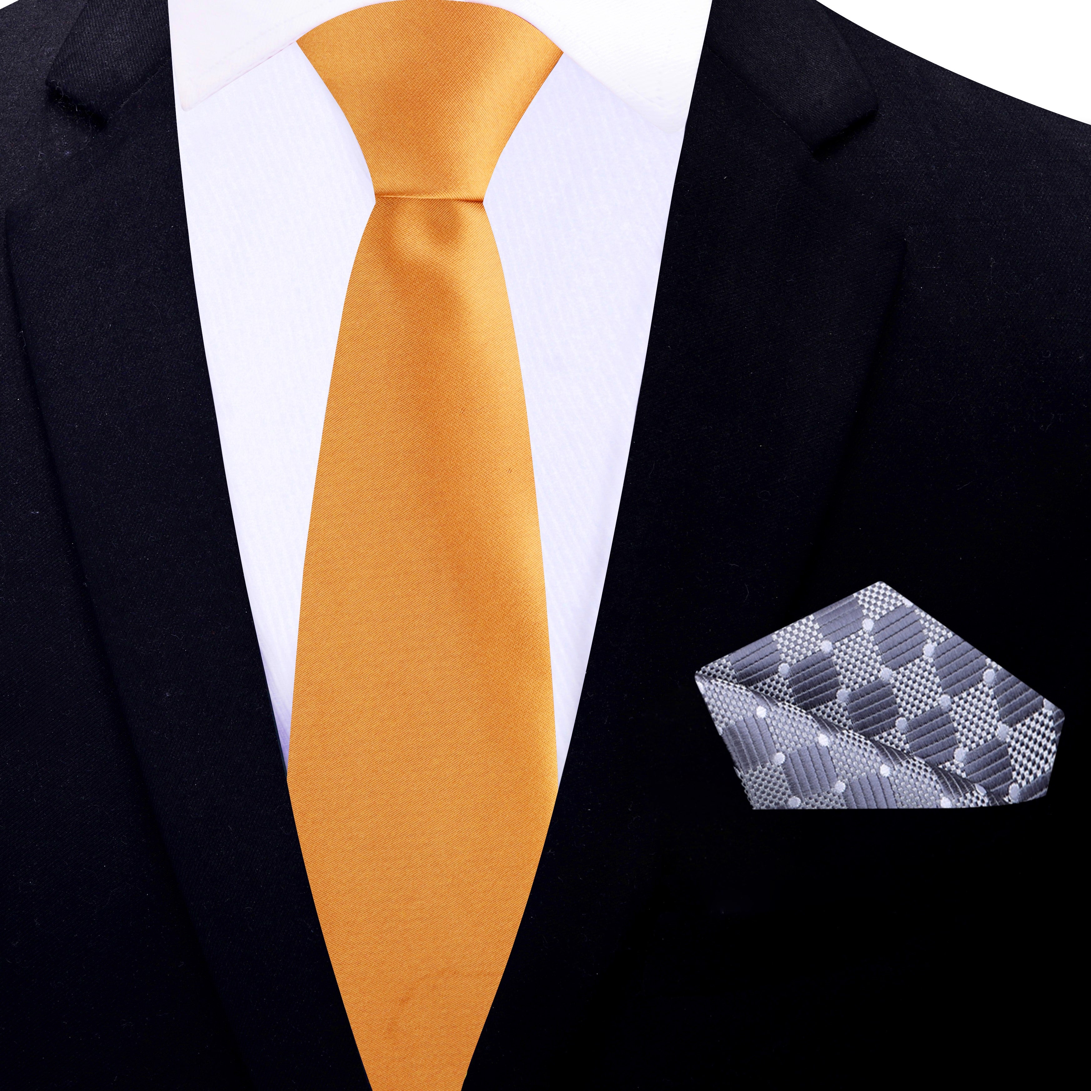 Formal mens necktie in marigold silk displayed with charcoal grey suit