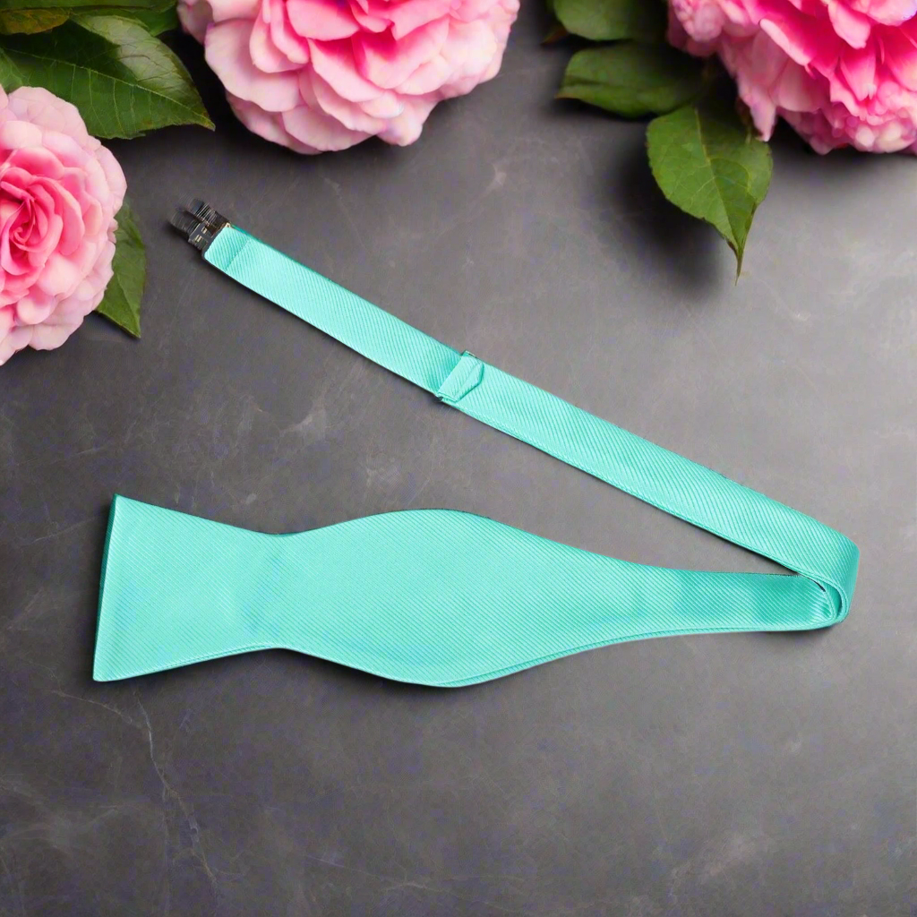 Close-up of the fabric texture of a mens mint blue bow tie