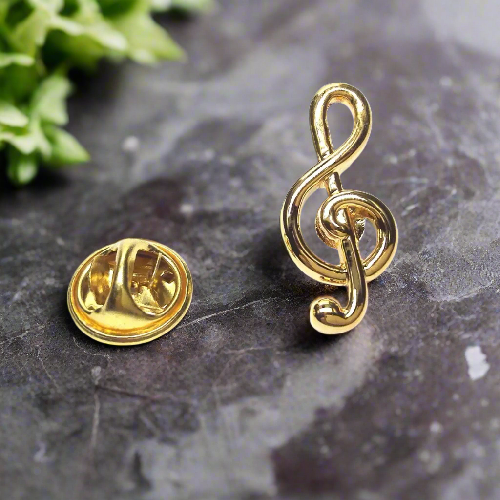 Gold treble clef lapel pin on a white dress shirt for formal events
