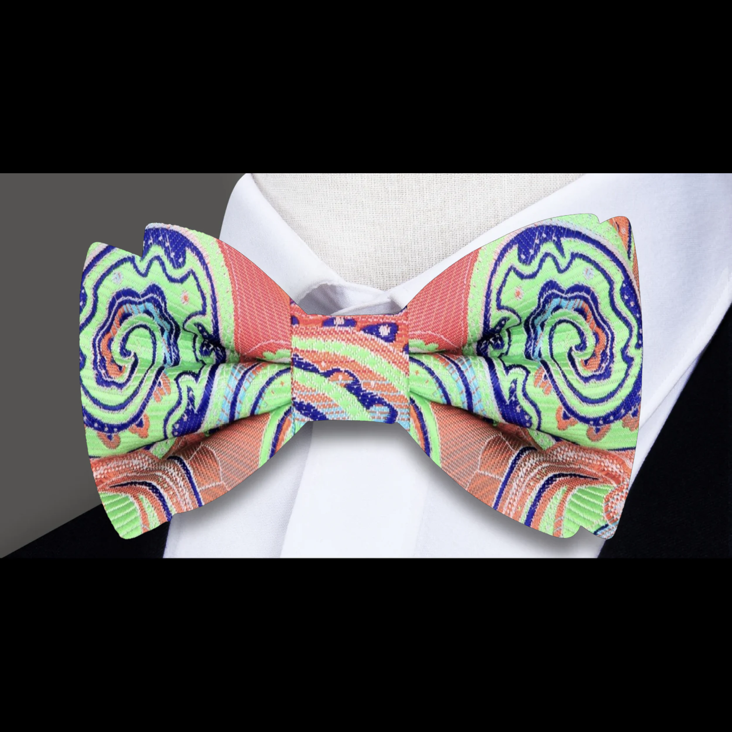 Tropics Paisley Bow Tie and matching pocket square, laid out against a dark suit background.