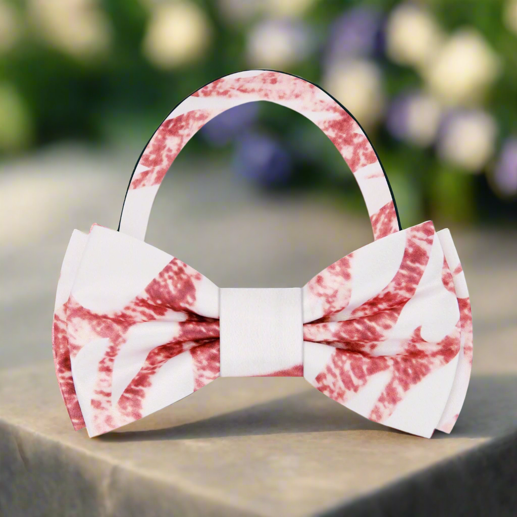 Close-up of rose gold marble bow tie on white dress shirt, showing silk texture and abstract pattern