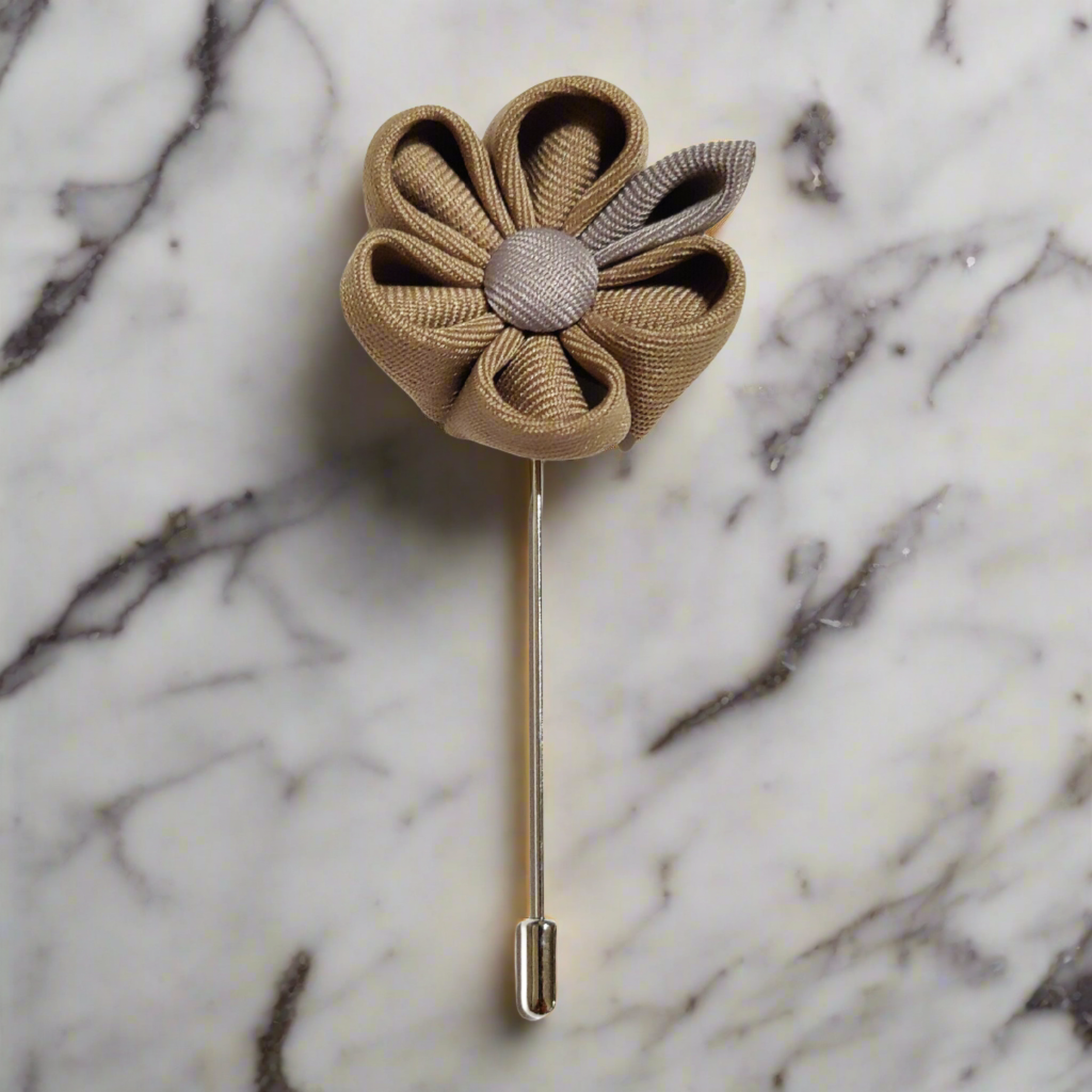 High-quality grey men's lapel flower pin displayed on a suit lapel.