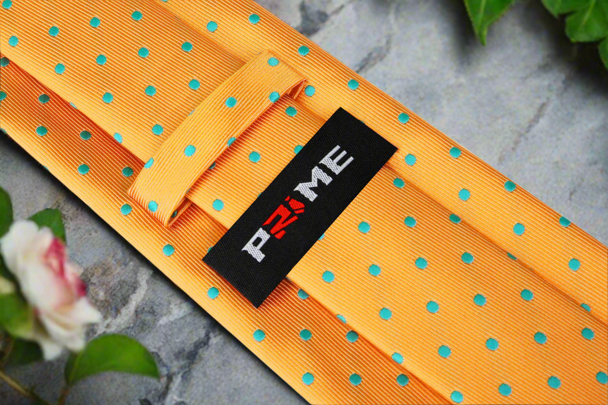 Close-up of the vibrant orange necktie showcasing aqua blue polka dots, styled with a navy suit.