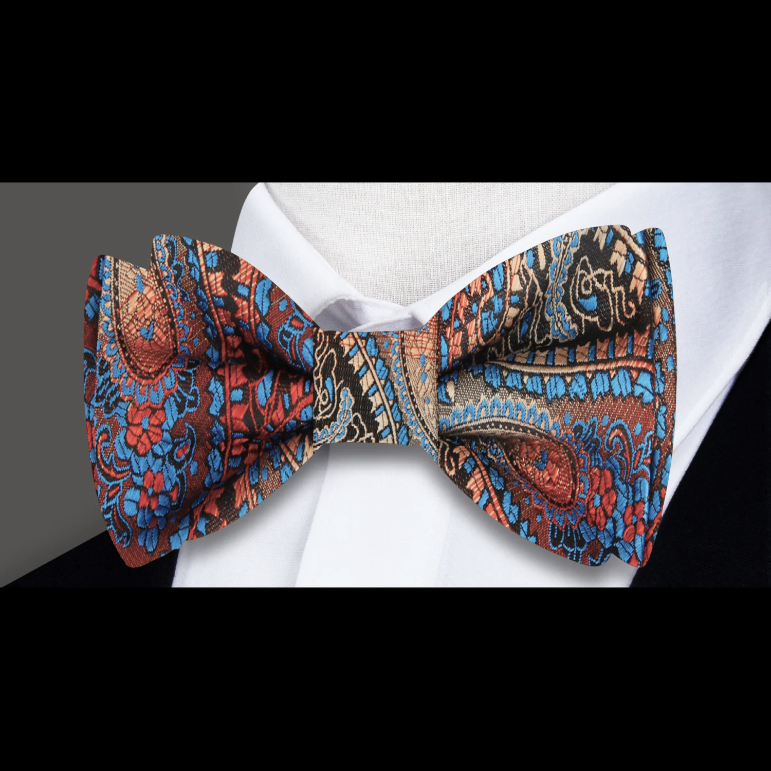 Close-up view of luxurious paisley self-tie bow tie showcasing intricate patterns.