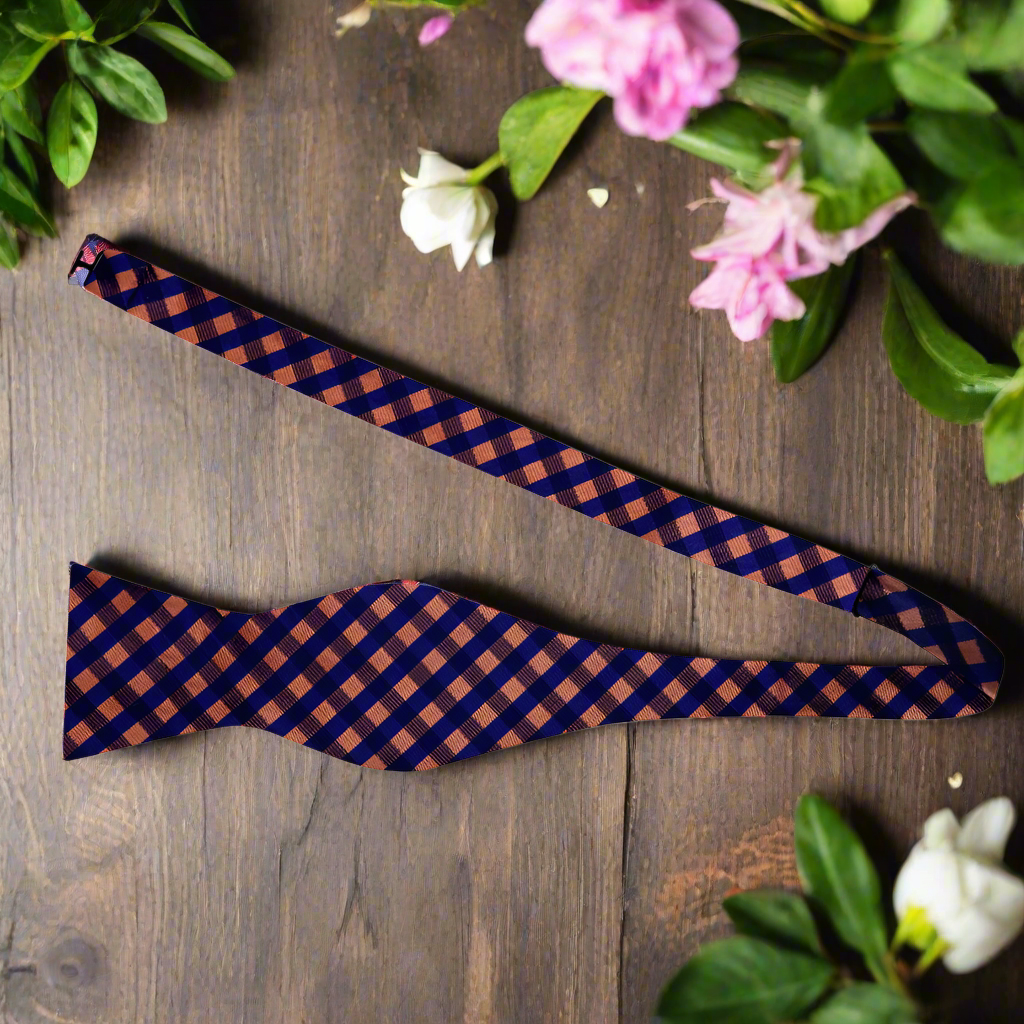 Man tying a self-tie bow tie in a formal setting, showcasing the elegant silk fabric