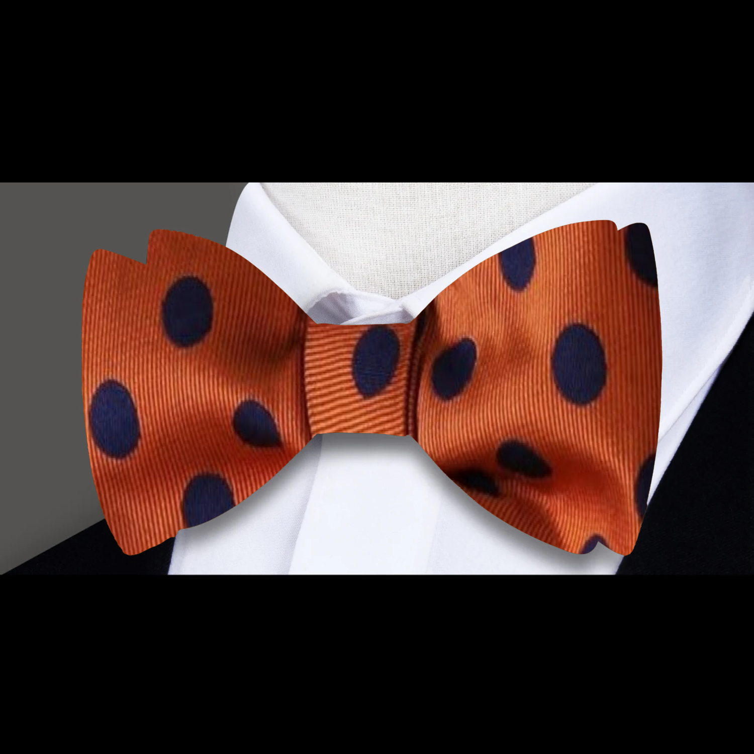 Close-up of elegant polka dot pre-tied bow tie in vibrant orange and blue colors