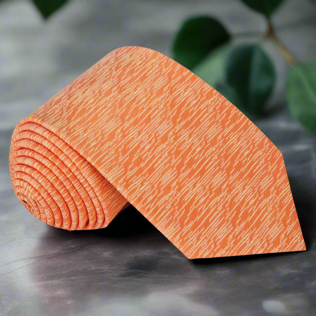 Close-up of the vibrant orange abstract silk necktie showing textured pattern